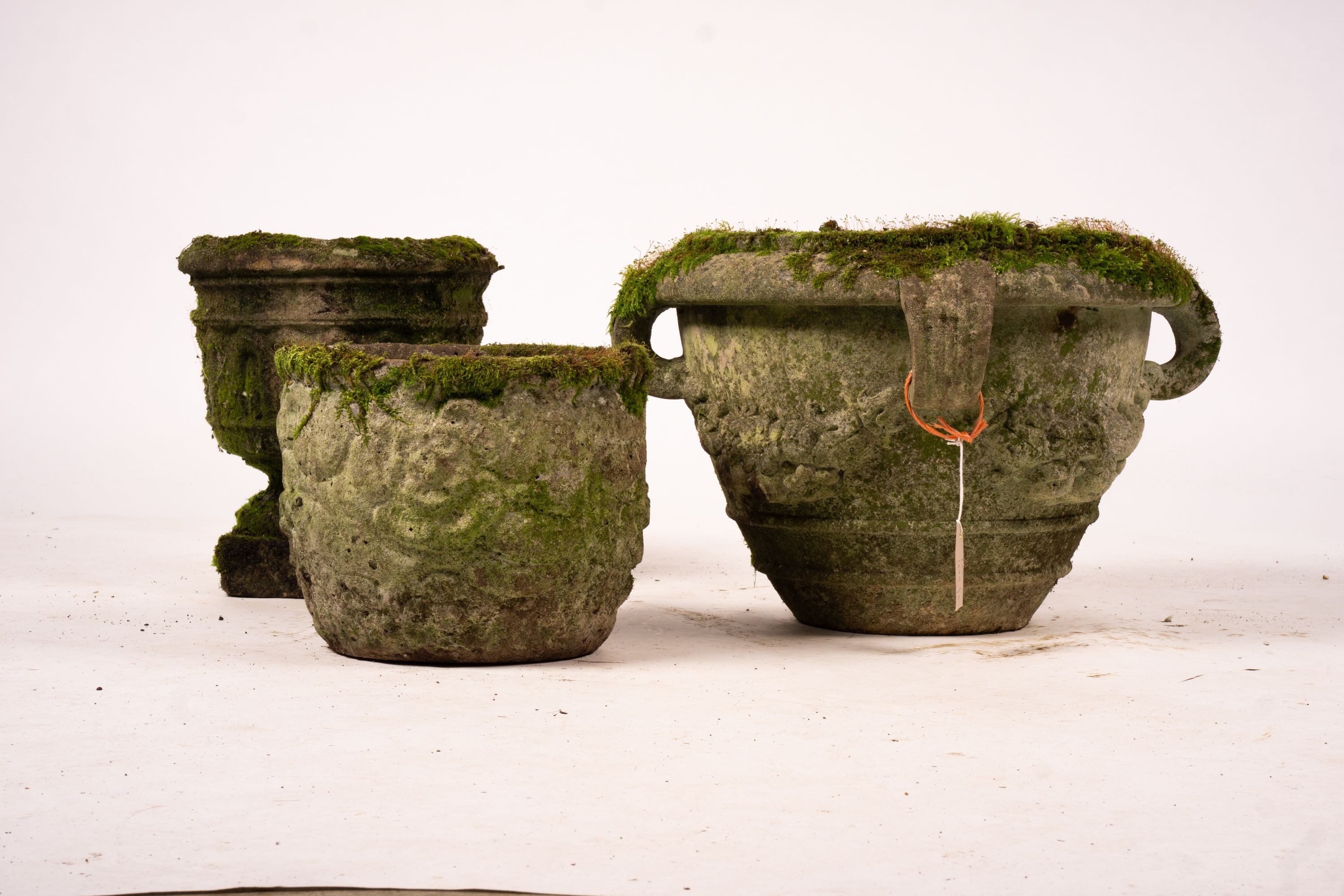 Three weathered reconstituted stone circular garden planters, largest Diam.52cm H.34cm